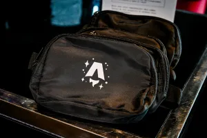 Una riñonera negra con la marca del logo de Astro Together en blanco.