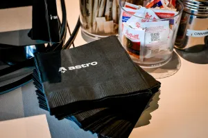 Pila de servilletas negras cuadradas con la marca del logo de Astro en blanco.