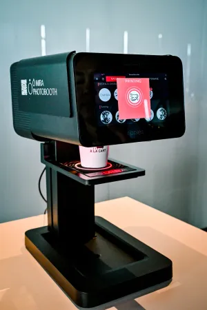 Máquina negra de impresión de arte en café.