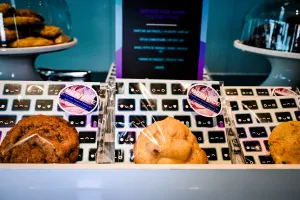 Primer plano de cookies en la barra de cookies gourmet. Las bolsas de cookies son transparentes con insertos con patrones de Houston. Las bolsas tienen la marca de Bernice, una panadería.