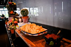 Bol grande de nachos junto a un bol mediano de salsa.