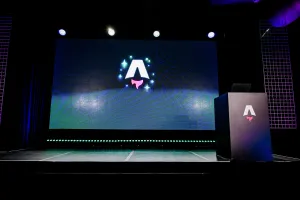 Un escenario vacío con una gran pantalla LED mostrando el logo de Astro Together. A la derecha, un podio negro con la marca del logo de Astro.