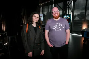 Dos core members de Astro, Erika y Nate, posan juntos. Nate lleva una camiseta de "Anti Javascript Javascript Club".