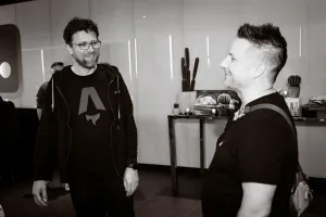 Una foto en blanco y negro de Matt Kane, anteriormente de Netlify y ahora core member de Astro, sonriendo con Nick Taylor, también anteriormente de Netlify.