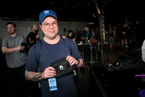 Un hombre sosteniendo una riñonera negra con la marca del logo de Astro Together en blanco.