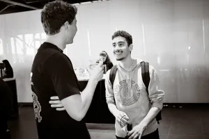 Fotos en blanco y negro de dos invitados masculinos charlando entre sí.