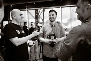 Foto en blanco y negro de Glauber, de Turso, hablando con Matthew, core contributor y framework lead en Astro, y un core maintainer de Astro.