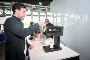 Un invitado masculino usando la máquina de impresión de café.