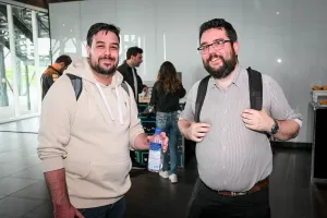Dos invitados masculinos posan juntos con sus mochilas.