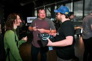Un grupo de invitados charlando mientras comen, beben, y sostienen su apparel.
