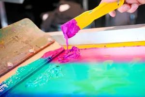 Primer plano del material tipo pintura usado en una prensa de impresión de camisetas.