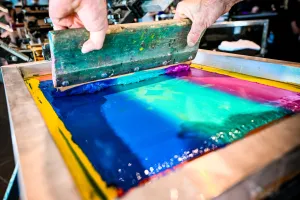 Primer plano del material tipo pintura usado en una prensa de impresión de camisetas.