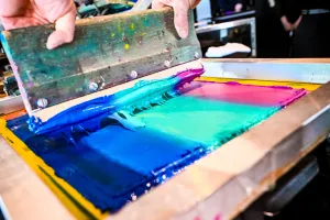 Primer plano del material tipo pintura usado en una prensa de impresión de camisetas.