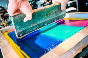 Primer plano del material tipo pintura usado en una prensa de impresión de camisetas.