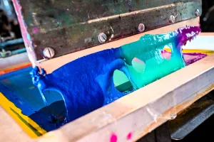 Primer plano del material tipo pintura usado en una prensa de impresión de camisetas.