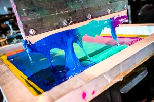 Primer plano del material tipo pintura usado en una prensa de impresión de camisetas.