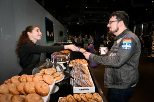 Un invitado recibiendo una cookie gourmet en la cookie bar.