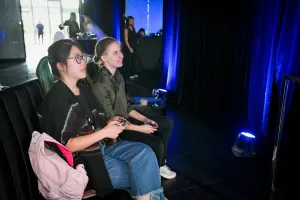 Dos mujeres mirando una TV, jugando a videojuegos intensamente.
