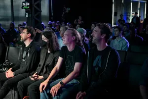 Una toma de la primera fila, donde los espectadores sonríen y ríen mientras ven a Ben Holmes en el escenario.