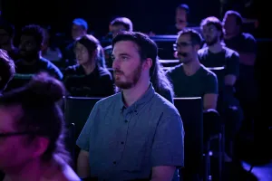 Una toma del público escuchando a Ben Holmes hablar en el escenario.