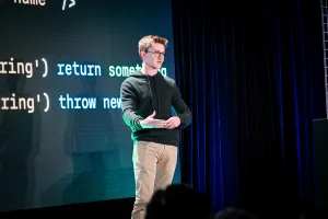 Ben Holmes en el escenario frente a una diapositiva con una diapositiva que muestra form data.
