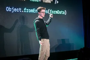 Ben Holmes en el escenario frente a una diapositiva con una diapositiva que muestra form data.