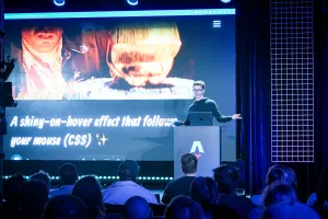Ben Holmes está de pie detrás de un podio de marca Astro en el escenario. Está compartiendo un demo.