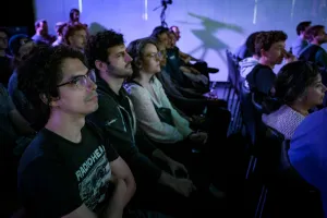 Una toma de una fila de miembros del público escuchando atentamente la presentación de la keynote.