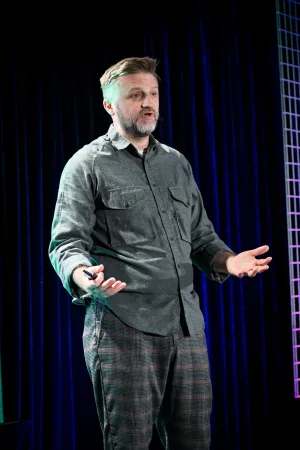 Retrato de Matthew Phillips hablando en el escenario.