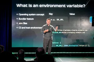 Matthew Phillips hablando en el escenario, explicando qué es una variable de entorno.