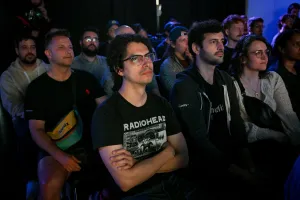 Miembros del público escuchando a Sarah Rainsberger hablar en el escenario.