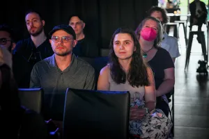 Miembros del público escuchando a Sarah Rainsberger hablar en el escenario.