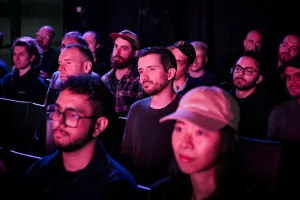 Miembros del público escuchando a Sarah Rainsberger hablar en el escenario.