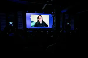 Vista desde el fondo del público mientras se reproduce un vídeo de contributors de Docs.