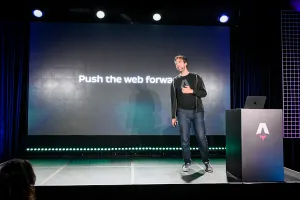 Fred K. Schott hablando en el escenario junto a un podio de marca Astro, frente a una diapositiva que dice, "Push the web forward".