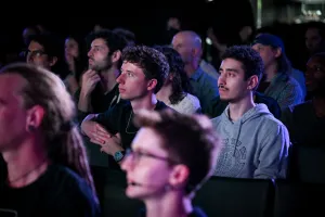 Miembros del público escuchando a Fred K. Schott hablar en el escenario.