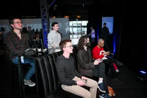 Varios miembros de Astro junto con un par de invitados jugando a Super Smash Bros.