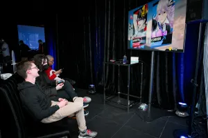 Varios miembros de Astro junto con un par de invitados jugando a Super Smash Bros.