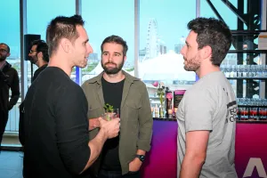 Invitados mezclándose con sus bebidas frente a la barra de alcohol.