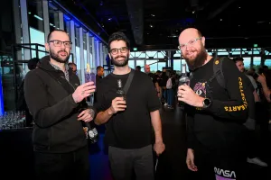 Invitados posando para una foto de grupo con sus bebidas.