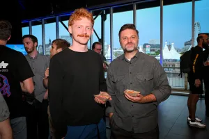 Matthew Phillips posa con un invitado mientras sostienen tacos.
