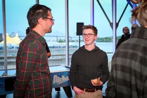 Ben Holmes sonríe mientras charla con un invitado.