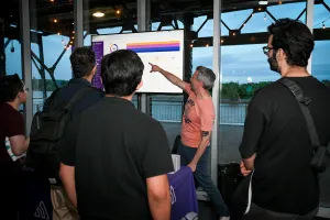 Representante de Sentry señalando un gráfico en la pantalla de TV en su stand de sponsor.