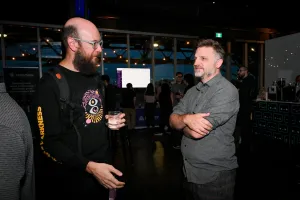 Matthew Phillips charlando con un invitado. Ahora está tan oscuro que el resto de invitados es difícil de ver y no se ve mucho por la ventana.