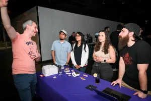 Sentry demuestra su producto a un grupo de invitados observadores en su stand de sponsor.