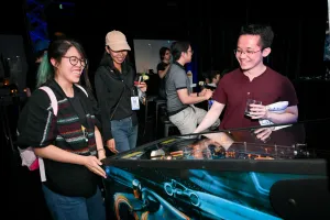 Invitados riendo mientras juegan al pinball.