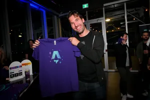 Fred K. Schott posando con una camiseta impresa púrpura con el logo de Astro.