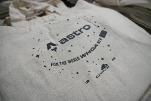 Una totebag de Astro gris pálido con un fondo de estrellas dispersas con los logos de Astro y Cloudflare. Para la web WHOA mundial